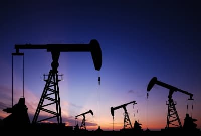Silhouetten mehrerer Ölförderpumpen in der Abenddämmerung
